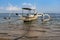 A white siling boat is bound through a blue roap during the touristic visit with cloudy sky background in Bali