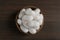 White silk cocoons in bowl on wooden table, top view