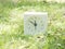White simple clock on lawn yard, 11:50 eleven fifty