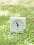 White simple clock on lawn yard, 11:55 eleven fifty five