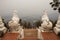 White singha statue guardian at Wat Phra That Doi Kong Mu Temple with landscape and cityscape of Maehongson hill valley city in