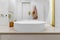 A white sink is photographed close-up in the bathroom. Gold Mixer