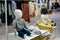 White sitting baby mannequin without face in a shop window of a children`s clothing store. Children`s casual clothing store.