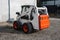 White skid steer loader at a construction site waiting of work. Industrial machinery. Industry.