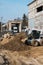 White skid steer loader at a construction site working with a soil. Industrial machinery. Industry.