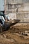 White skid steer loader at a construction site working with a soil. Industrial machinery. Industry.