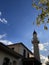 A White Small Masjid And A Minaret Against Bright Blue Sky