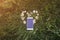 White smartphone is lying on camomile flowers heart on the grass. Green photo summer concept. Nature and new technologies love