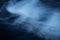 White smoke on black fabric background. Smoke spreads over the background. Vaping culture, life without cigarettes