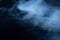 White smoke on black fabric background. Smoke spreads over the background. Vaping culture, life without cigarettes