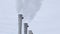 White smoke comes out in horrific clouds from old chimney of factory plant or power plant, polluting environment. Toxic