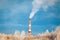 White smoke from a high pipe of a boiler plant on a winter day