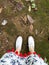 White sneakers woman feet on green grass