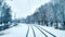 White snow in city on a tramway in November, first snow December. Snow-covered city with trees in winter. Rails sleepers