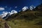 White snow peaks above green meadows