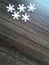 White snowflakes. Wooden background. Crystal ornament. Fragile crystals of bizarre shape. Festive decoration. Christmas decorative