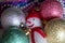 White snowman in a red scarf with Christmas balls and beads