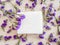 White soap bar on a wooden background with violet flovers top view. Pure natural soap with cedar oil and herbal ingredients.