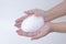 White soapy foam bubbles texture on hand.  cleaning and wash essence facial cleanser skin care background concept