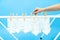 White socks hanging on drying rack on blue background