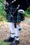 White socks. A man with a bagpipe, a kilt in a cage with a green and red stripe.Culture. The details of the skirt of the