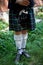 White socks. A man with a bagpipe, a kilt in a cage with a green and red stripe. Culture.The details of the skirt of the