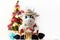 White soft toy bull on a light background with a Christmas tree and garlands, New Year`s card. Chinese Year of the Ox, zodiac