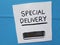 White special delivery sign on blue wall with slot