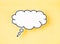 The White speech bubble shaped post it note on yellow background with copy space