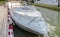 A white speedboat docked on a river