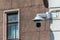 White spherical outdoor surveillance camera on the corner of the facade of the building in a public place