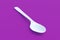 White spoon on violet background