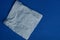 White square crumpled napkin lying on a blue table