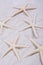 White starfishes on sand background