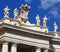 White statues on top of Vatican building, blue sky