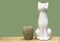 White statuette of a cat on a green background