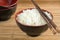 White steamed rice in a bowl with chopsticks