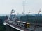 White steel bridge with traffic of several trucks and cars in morning light