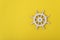 White steering wheel on yellow background. Marine theme. Yacht management. Copy space