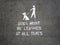 A white stencil on a concrete floor stating dogs must be leashed