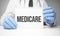 White sticker with text medicare in doctor& x27;s hands with a stethoscope