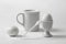 White still life with a mug and an egg
