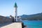 White stone lighthouse tower on the pier