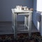 White stool with a branch of cotton flowers on a wall background with a shadow from window