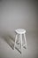 White stool with shadow on white background. Location in studio with tabouret on white background