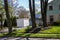 White storage pod unit in the driveway of a home that has solar panels on it`s garage roof and large trees on it`s lawn.