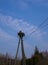 A white stork stands in a nest that is folded on a pole for wires