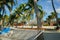 White string hammock strung between coconut palms on idyllic tropical island beach