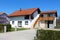 White suburban family house with with outdoor stone tiles steps and attached garage with metal garage doors and paved driveway