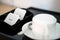 White sugar packet with coffee cup and kettle set in hotel room